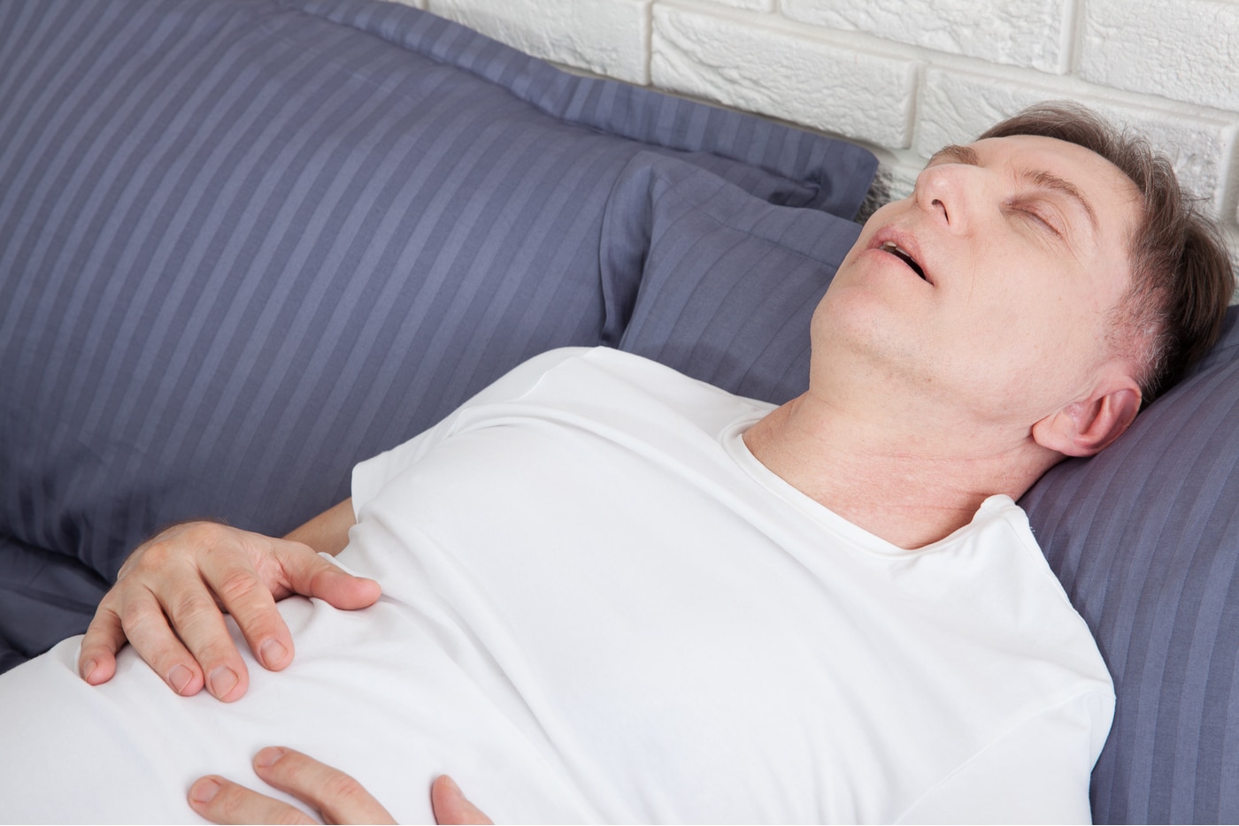 śpiący mężczyzna śpi na plecach i ma problemy z bebechem sennym